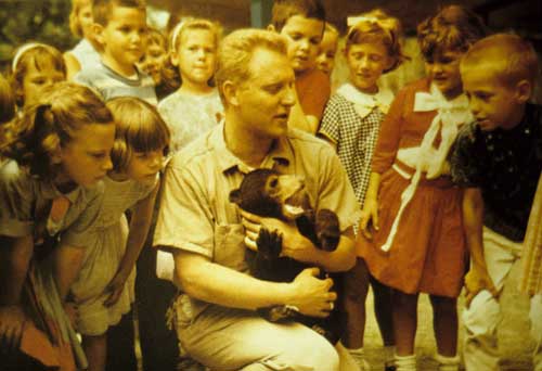 Charlie Hoessle showing bear cub to children. 