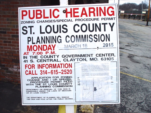 Sign announcing public hearing on former johnny's Market property.