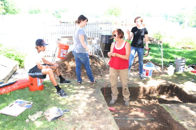 Robin, in center wearing red, working with the high school students on the dig at Sappington House, excavation unit one.